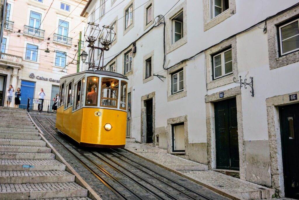 A classic yellow tram climbs the steep, narrow streets of Lisbon, a scene that captures the city's old-world charm and serves as an iconic means of transport for visitors crafting their Lisbon itinerary.