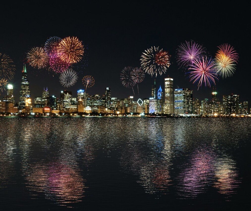 Fireworks over the Chicago Skyline and Lake Michigan in a dark, night sky.