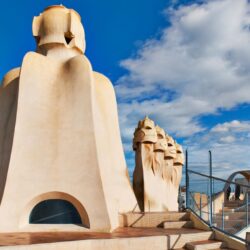 The unique chimneys and undulating architecture of Casa Milà's rooftop against a blue sky, a testament to Gaudí's modernist vision, and a highlight on any Barcelona itinerary.